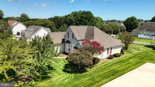an aerial view of residential houses with outdoor space and trees