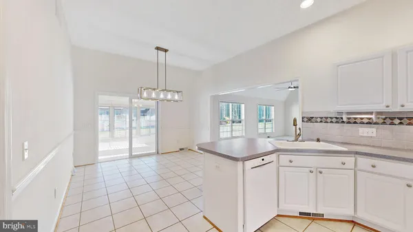 an empty room with windows and ceiling fan