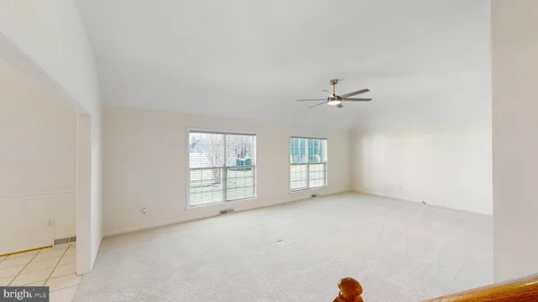 an empty room with a ceiling fan and window