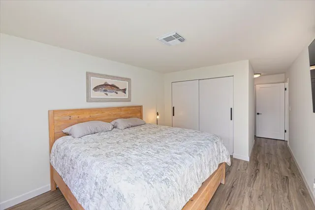 a bedroom with a bed and a painting on the wall