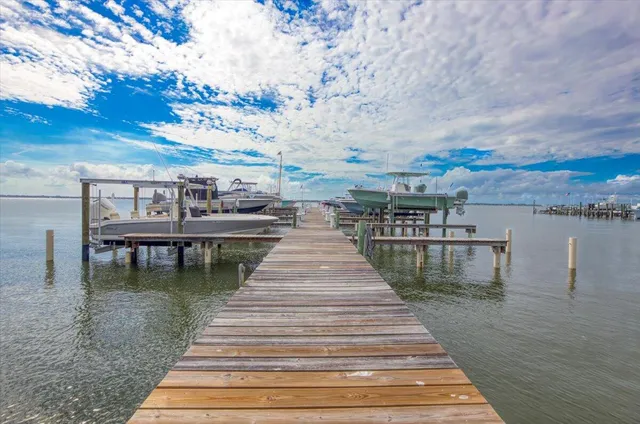 a view of a street with a big yard and large trees