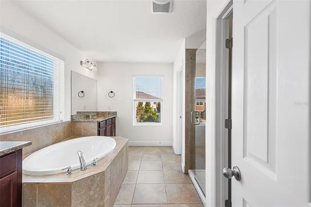 a white bath tub sitting in a bathroom next to a window