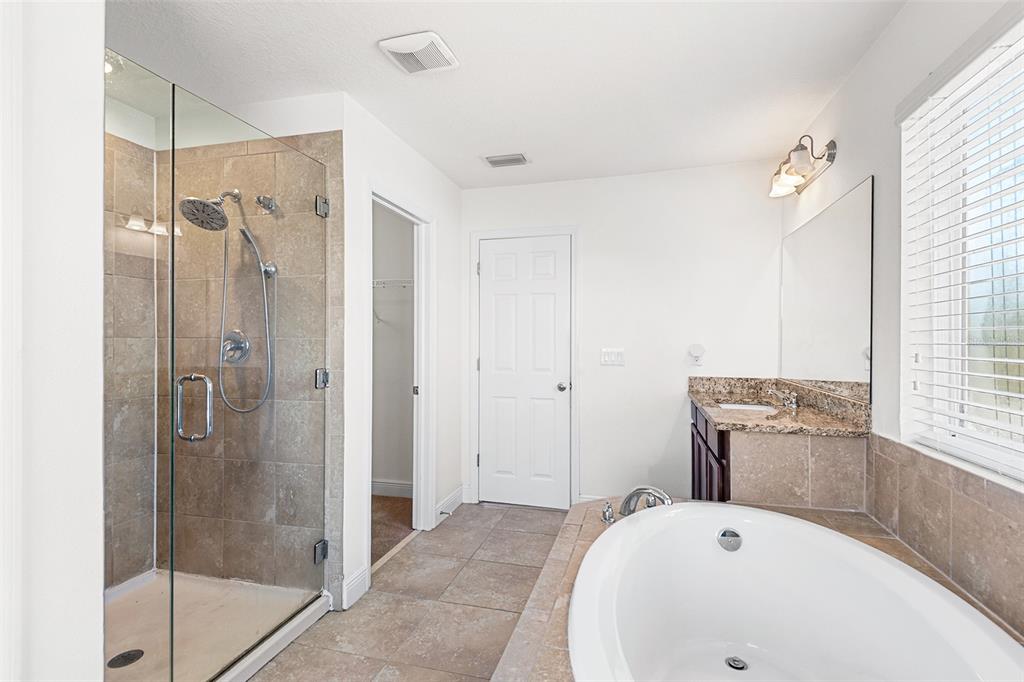 1848 Oak Hammock Court Lutz, FL 33558 - Photo 16 of 25 a bathroom with a bathtub and a shower