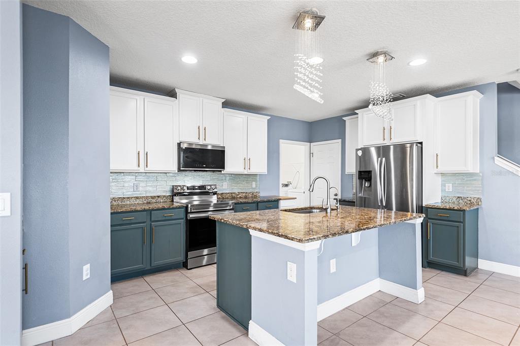 1848 Oak Hammock Court Lutz, FL 33558 - Photo 3 of 25 a kitchen with stainless steel appliances granite countertop a sink stove and refrigerator