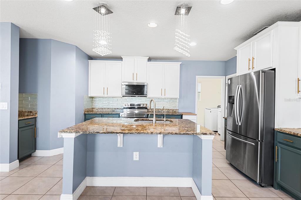 1848 Oak Hammock Court Lutz, FL 33558 - Photo 4 of 25 a kitchen with kitchen island granite countertop stainless steel appliances cabinets a sink and a counter top space