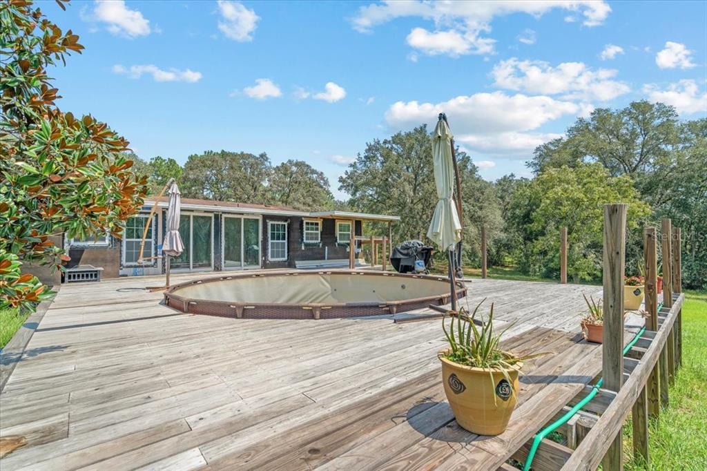 13120 Southwest 90th Street Dunnellon, FL 34432 - Photo 21 of 24 a view of a patio with couches table and chairs with wooden floor and fence