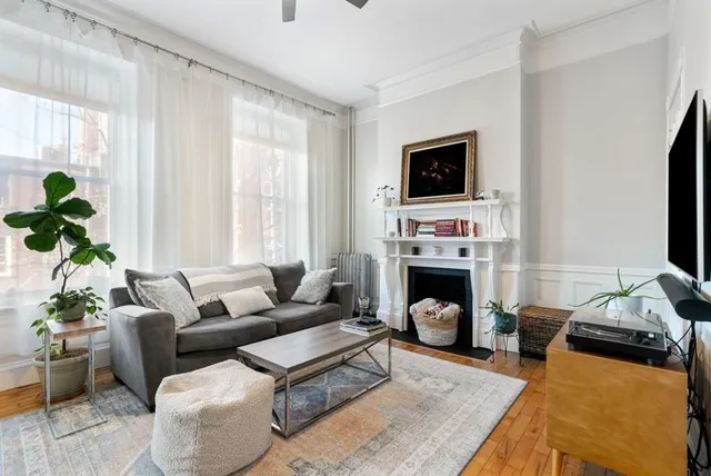 a living room with furniture a flat screen tv and a fireplace