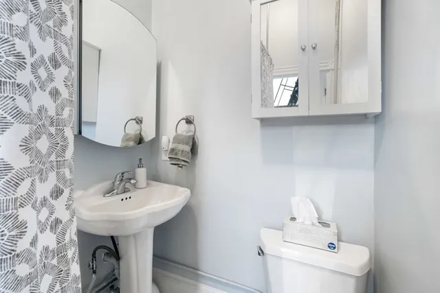 a bathroom with a sink a mirror and toilet