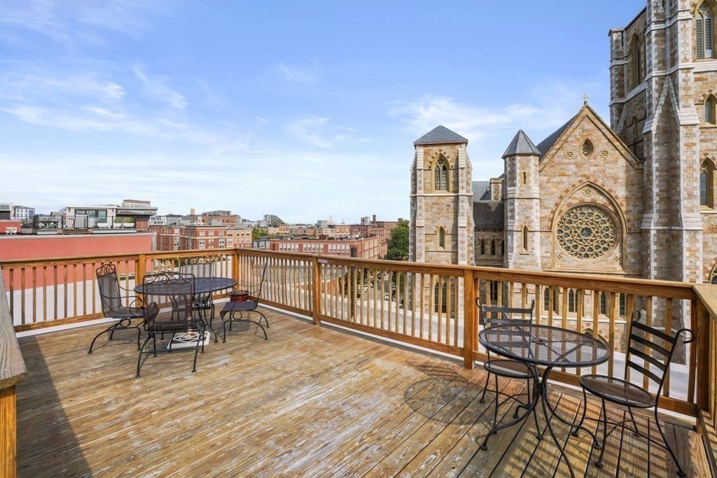 1411 Washington Street, Unit 5 Boston, MA 02118 - Photo 16 of 19 a view of a balcony with table and chairs and wooden floor