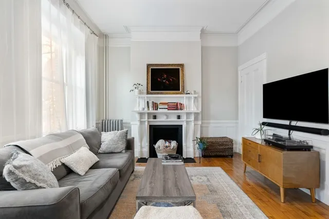 a living room with furniture a flat screen tv and a fireplace