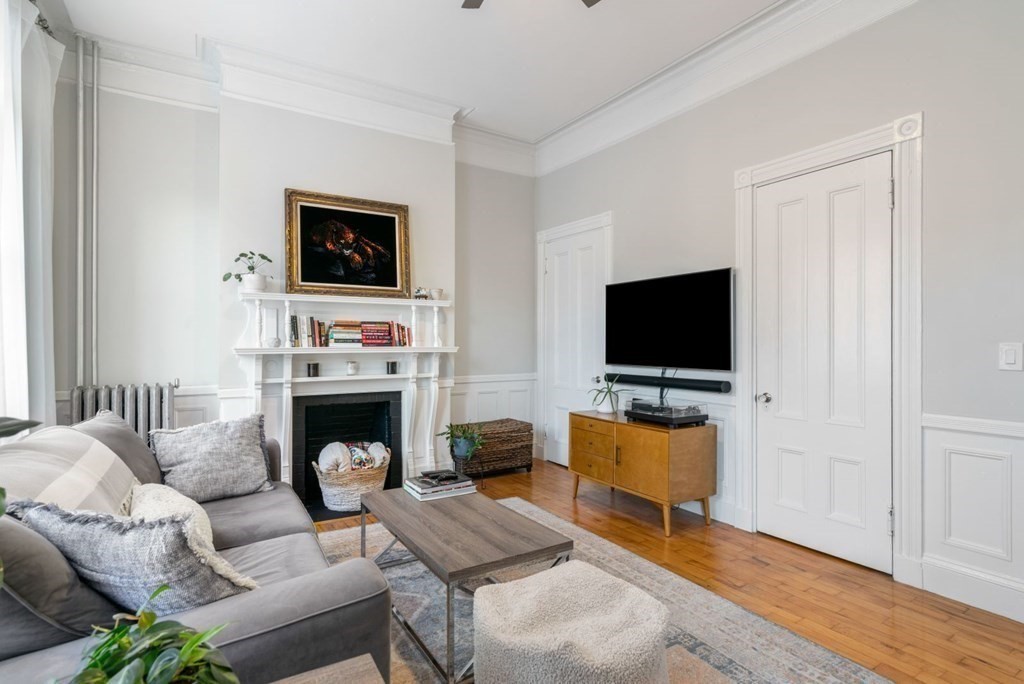 1411 Washington Street, Unit 5 Boston, MA 02118 - Photo 3 of 19 a living room with furniture a flat screen tv and a fireplace