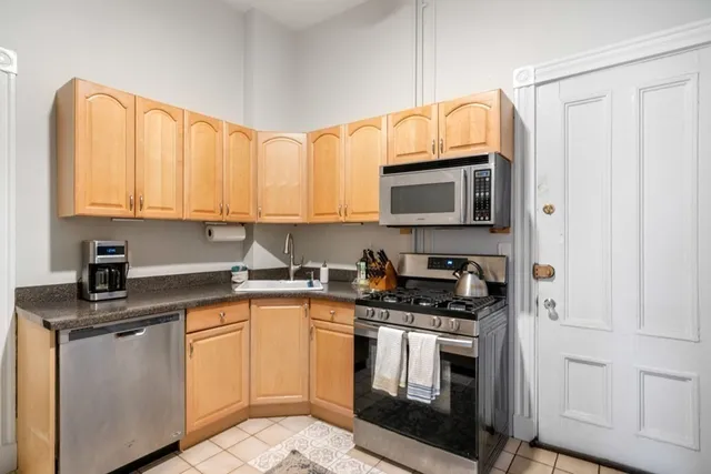 a kitchen with stainless steel appliances granite countertop a stove a sink and a microwave