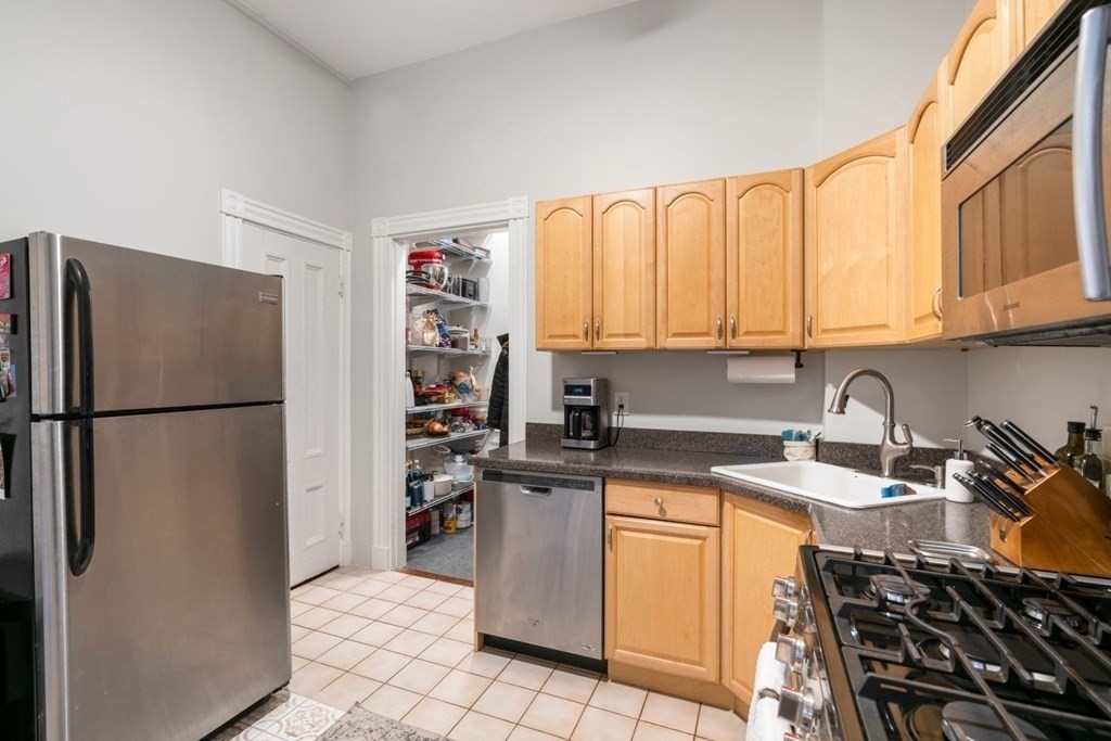 1411 Washington Street, Unit 5 Boston, MA 02118 - Photo 9 of 19 a kitchen with stainless steel appliances granite countertop a refrigerator sink and stove