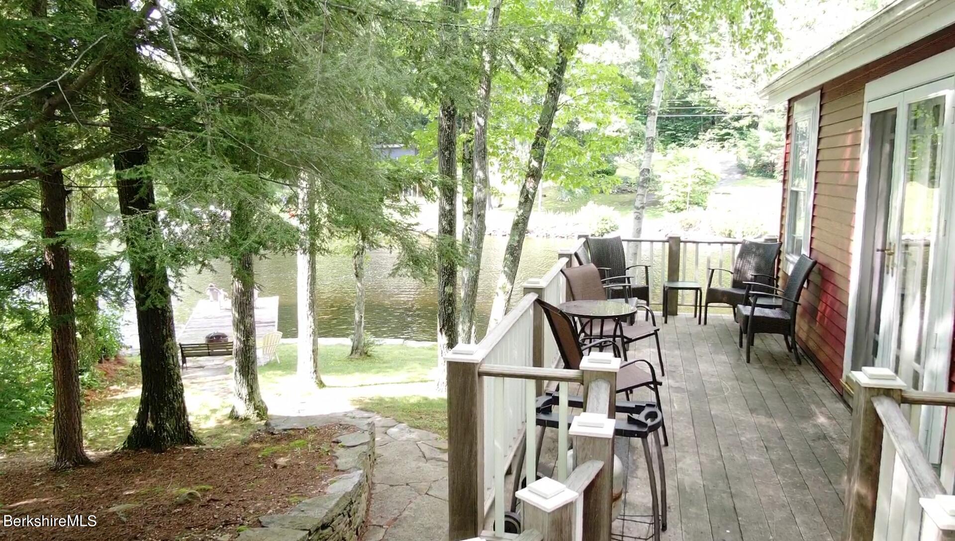 5 South Gate Island Road Otis, MA 01029 - Photo 5 of 38 a view of a patio with table and chairs and floor to ceiling window