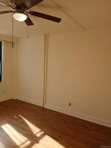 a view of a room with wooden floor and fan