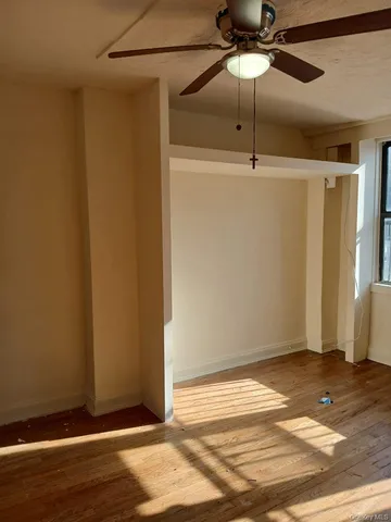 a view of a room with wooden floor and fan
