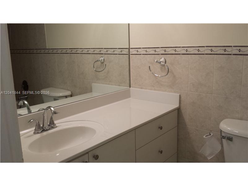 8610 Southwest 149th Avenue, Unit 504 Miami, FL 33193 - Photo 11 of 13 a bathroom with a sink and a mirror