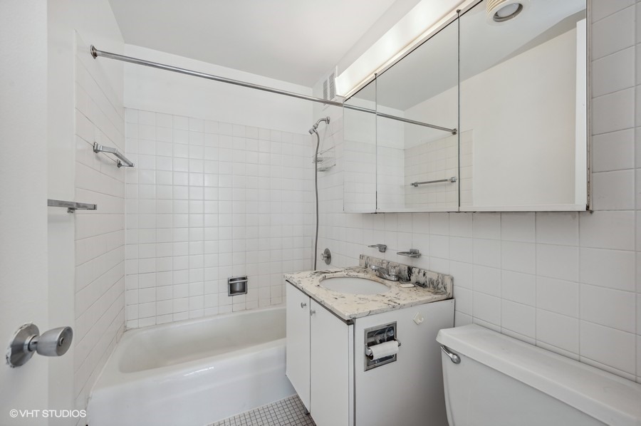 655 West Irving Park Road, Unit 5202 Chicago, IL 60613 - Photo 11 of 26 a bathroom with a granite countertop sink a toilet and shower