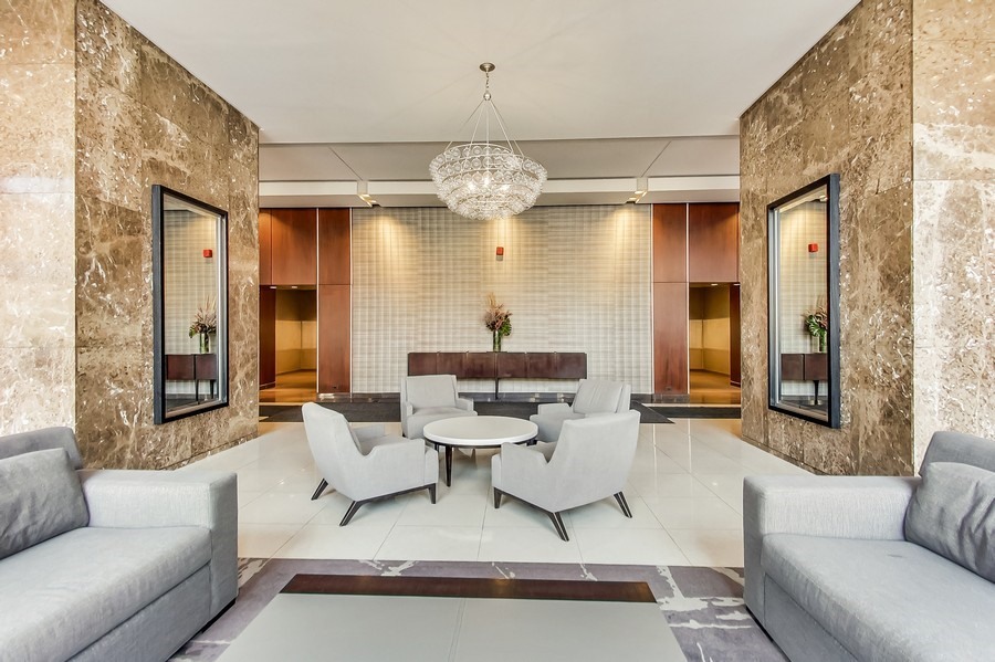 655 West Irving Park Road, Unit 5202 Chicago, IL 60613 - Photo 16 of 26 a living room with couch a dining table and a chandelier