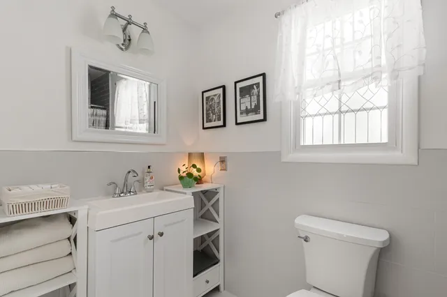 a bathroom with a sink toilet and window