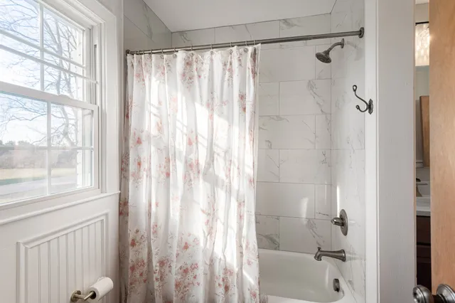 a bathroom with a shower curtain and a window