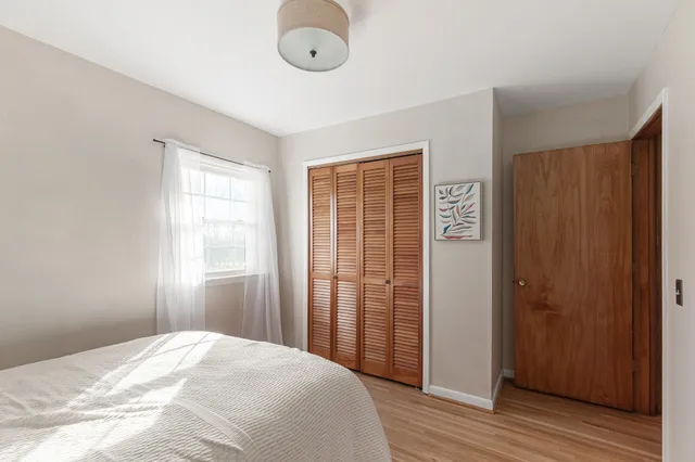 a view of a bedroom with wooden floor and windows