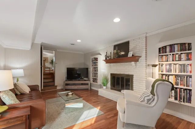 a living room with furniture a flat screen tv and a fireplace