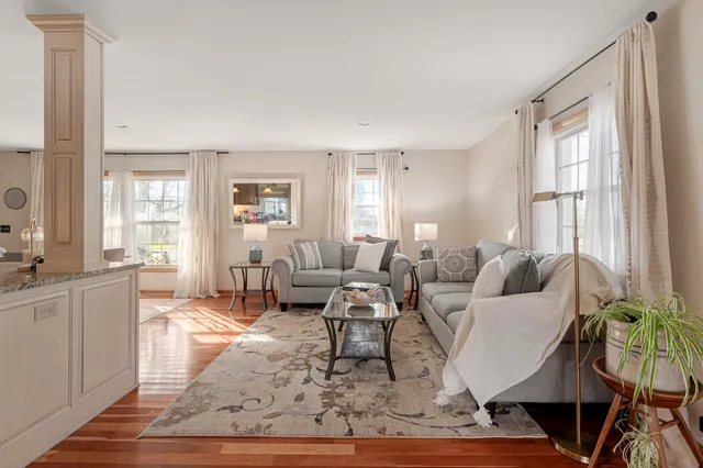 a living room with furniture wooden floor and a large window
