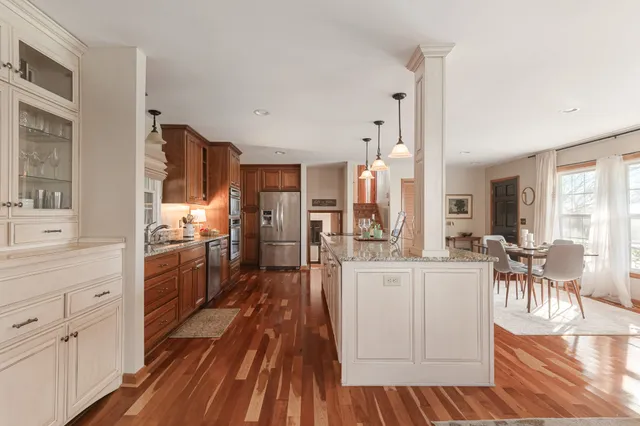 a kitchen with white cabinets and wooden floor