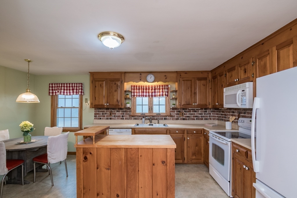 88 Buffam Road Pelham, MA 01002 - Photo 19 of 42 a kitchen with a stove a sink a refrigerator and a dining table