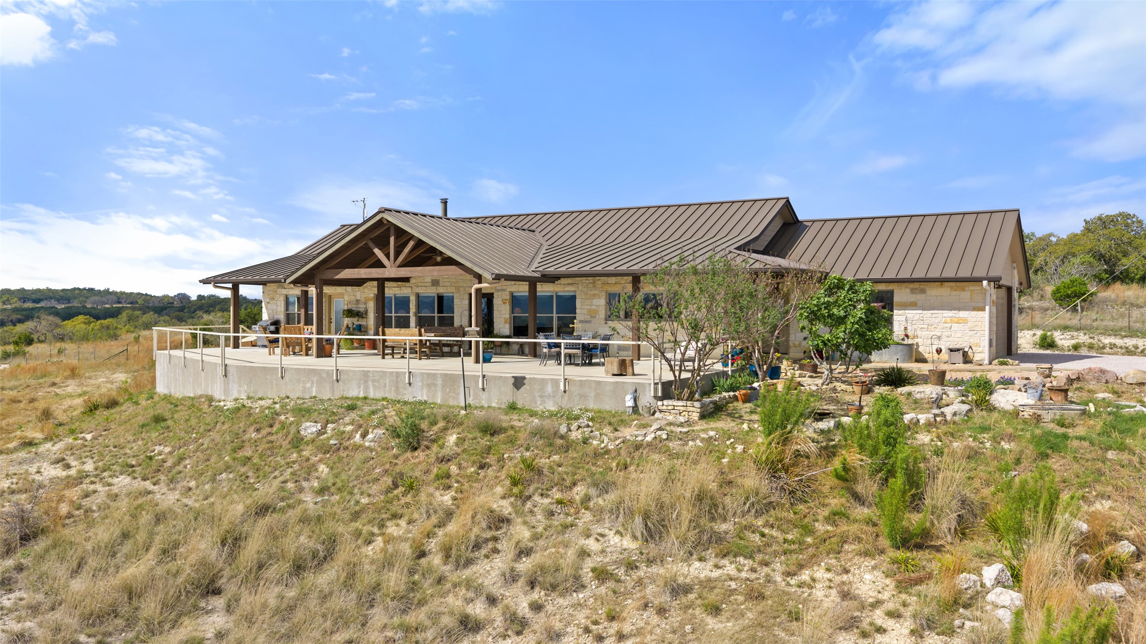 546 Lazy Oak Road Hye, TX 78635 - Photo 1 of 34 Back of house featuring a patio, stone siding, and a standing seam roof