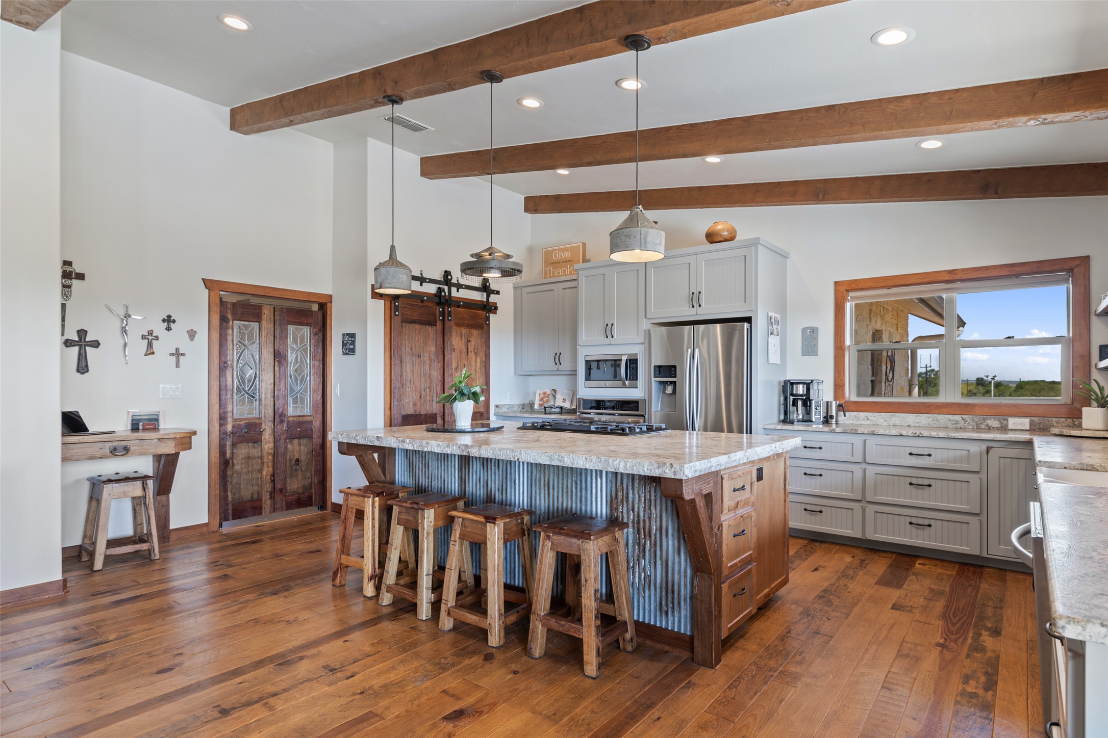 546 Lazy Oak Road Hye, TX 78635 - Photo 8 of 34 Kitchen featuring dual tone cabinets, a kitchen island, hanging light fixtures, stainless steel appliances, and dark wood finished floors
