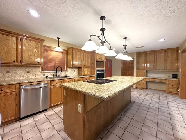 a large kitchen with kitchen island a sink stainless steel appliances and cabinets