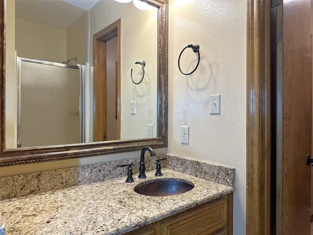 a bathroom with a granite countertop sink and a mirror