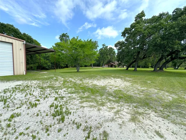 a view of a green field with wooden fence