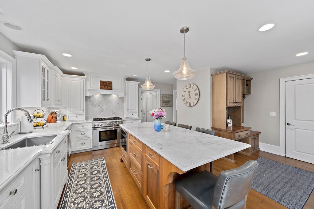 273 Wareham Street Middleboro, MA 02346 - Photo 5 of 42 a kitchen with a stove a kitchen island a sink dishwasher a dining table and chairs with wooden floor