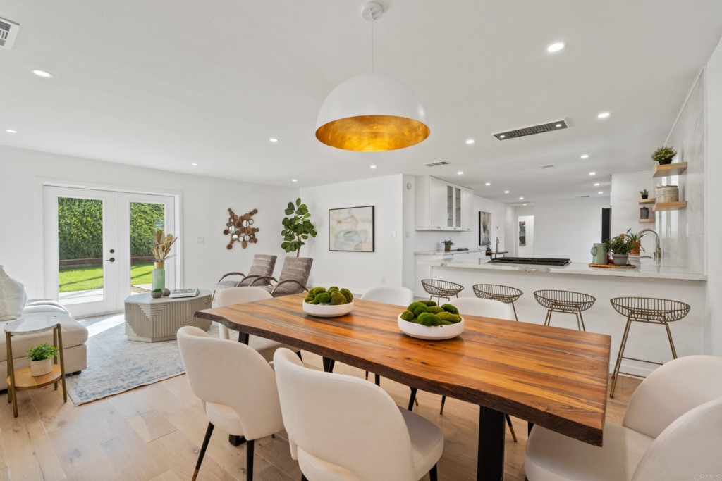 a dining room with stainless steel appliances a table and chairs