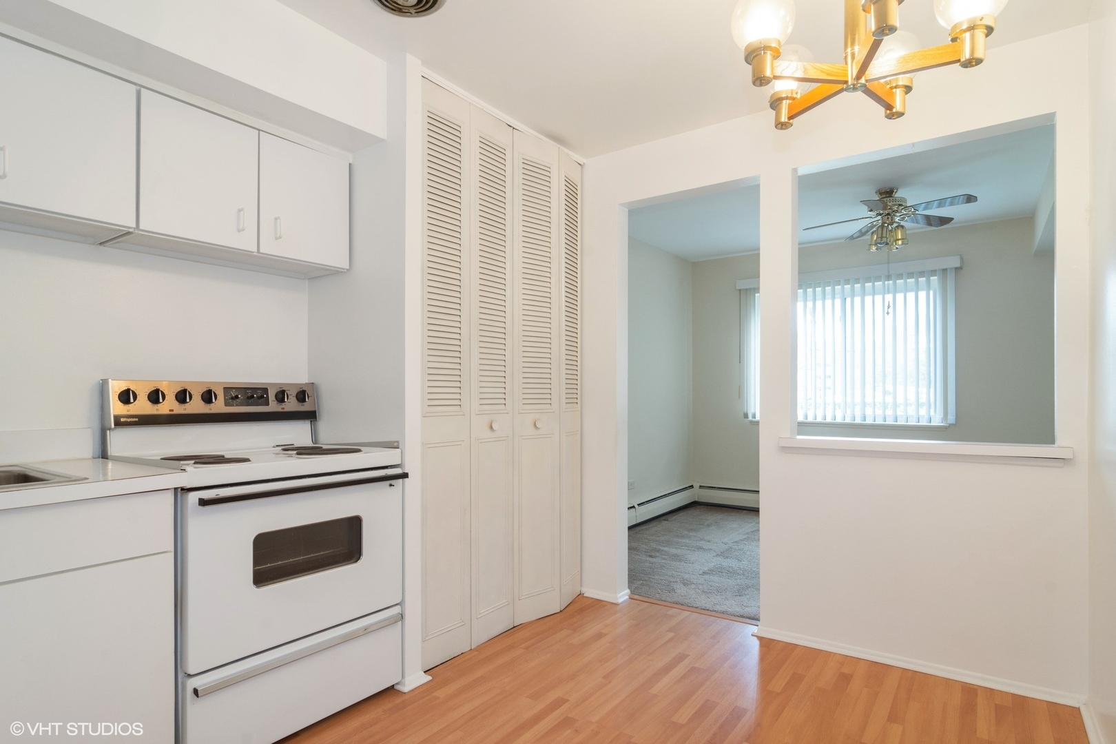 2407 East Brandenberry Court, Unit 1L Arlington Heights, IL 60004 - Photo 5 of 10 a kitchen with a stove cabinets and wooden floor