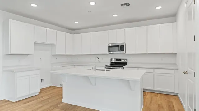 a kitchen with cabinets appliances a sink and a counter space