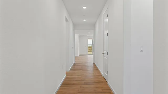 a view of a hallway with wooden floor
