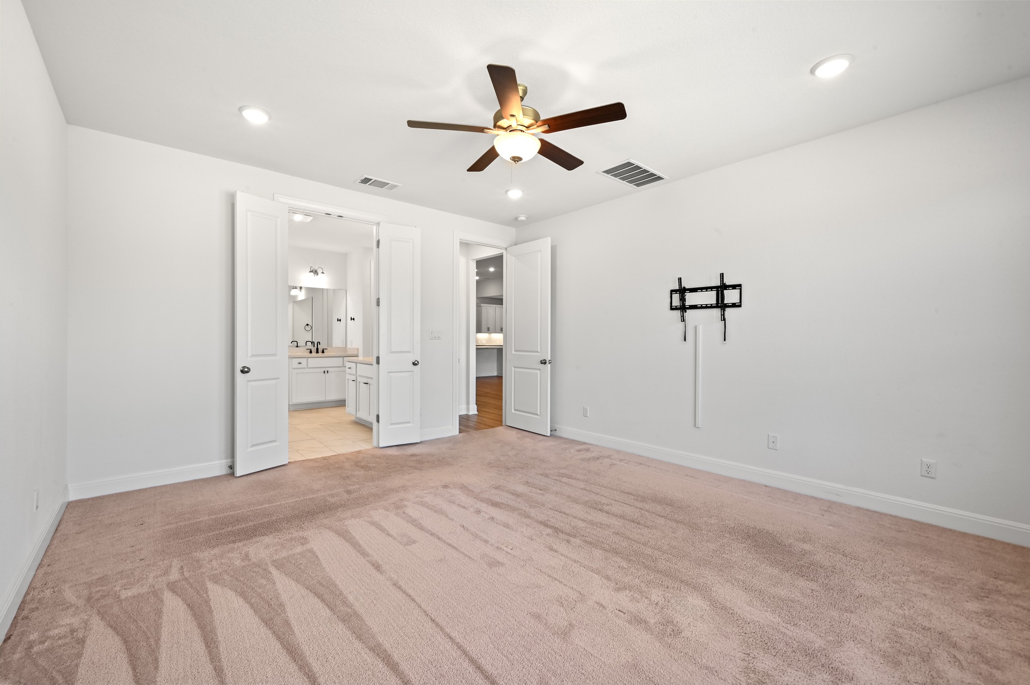 433 Running Bird Road Austin, TX 78737 - Photo 18 of 40 A spacious bedroom features plush carpet and an en-suite bathroom with double vanities, offering comfort and privacy.