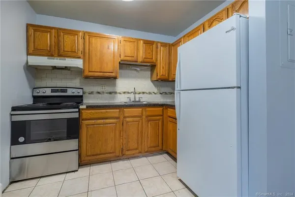 a kitchen with a refrigerator sink and cabinets
