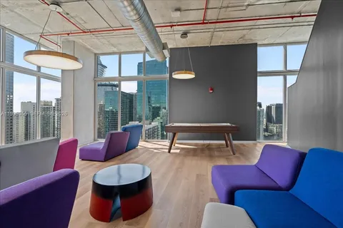 a living room with furniture and a floor to ceiling window
