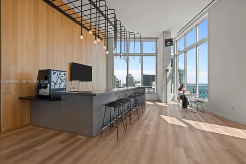 a kitchen with stainless steel appliances a microwave a stove and white cabinets with wooden floor