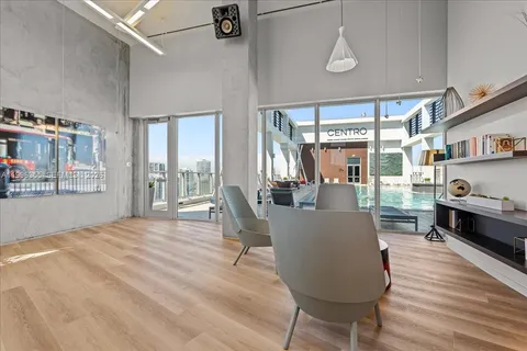 a living room with furniture a flat screen tv and wooden floor