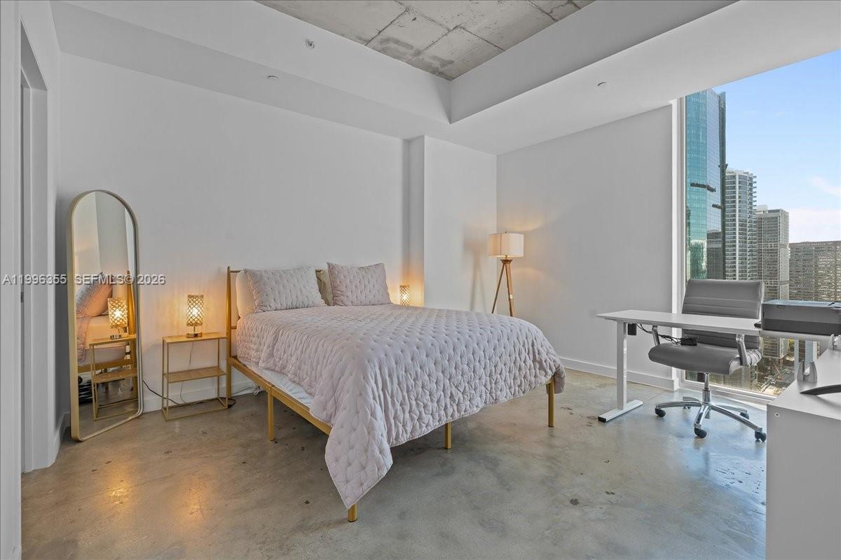 151 Southeast 1st Street, Unit 3107 Miami, FL 33131 - Photo 3 of 30 a spacious bedroom with a bed and a table in it