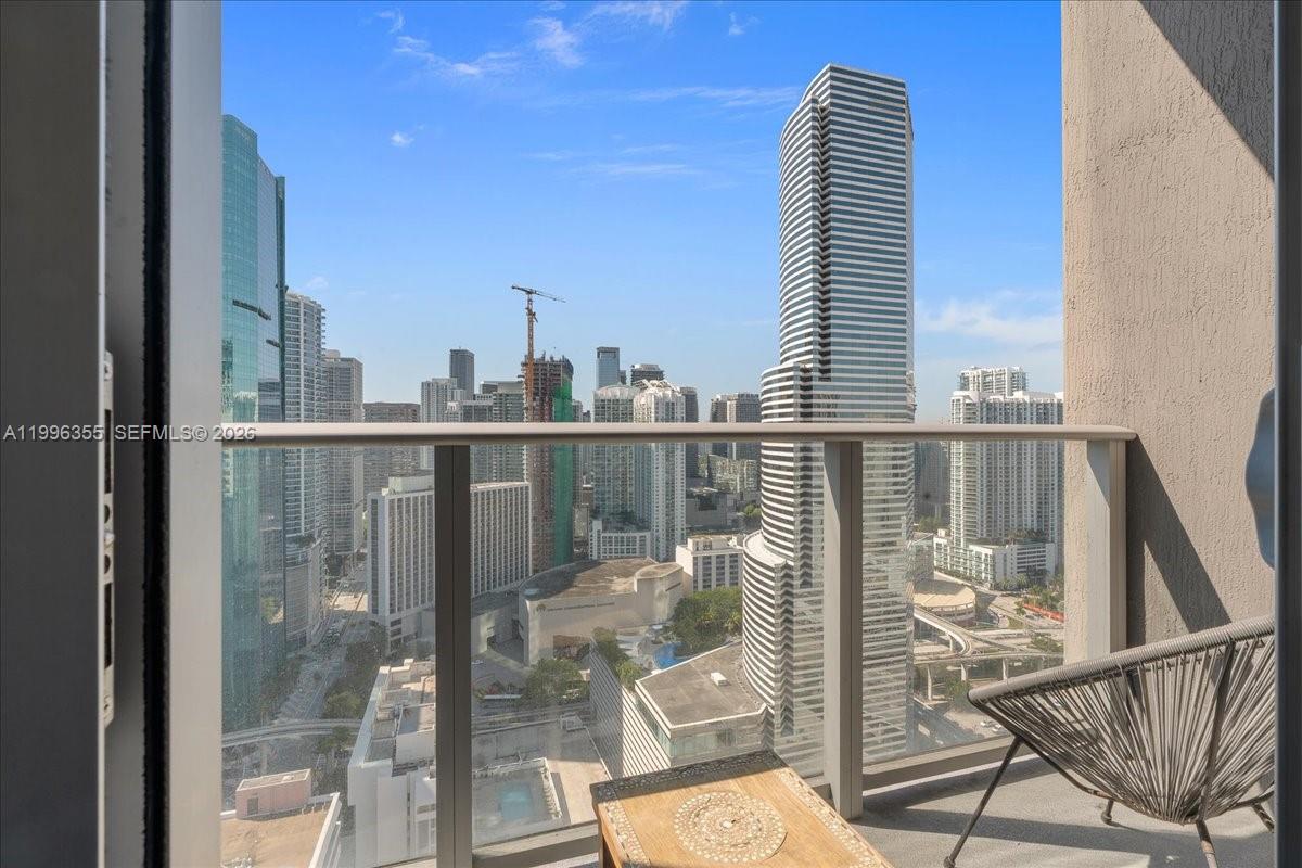 151 Southeast 1st Street, Unit 3107 Miami, FL 33131 - Photo 4 of 30 a view of a balcony with floor to ceiling windows and wooden floor