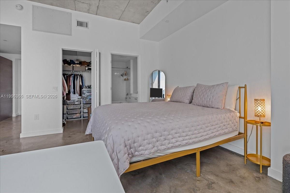 151 Southeast 1st Street, Unit 3107 Miami, FL 33131 - Photo 7 of 30 a bedroom with a bed and a walk in closet