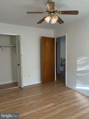 a view of an empty room with a window and a ceiling fan