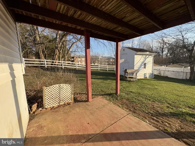 a view of a porch with wooden floor and roof with a garden view
